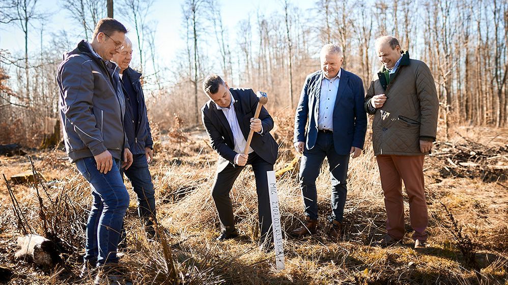Landrat André Schröder (Mitte) markiert den künftigen Standort des Mobilfunkmasts in Stolberg mit einem Holzpfahl