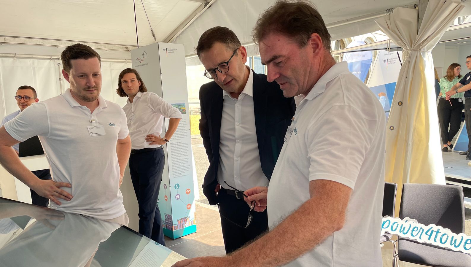 Staatssekretär Stefan Schnorr (Mitte) im Gespräch mit Mitarbeitern der MIG.