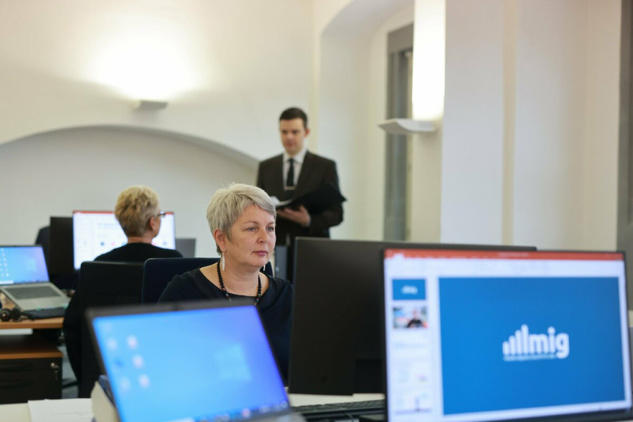 Zwei Frauen und zwei Männer mit Tablet PCs und Smartphone sitzen in der Runde auf Sesseln und diskutieren.