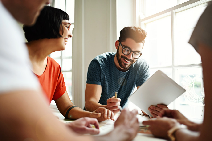 Zwei Frauen und zwei Männer am Tisch bei der Teamarbeit.